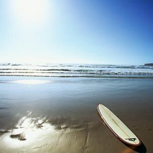 photo-thematique-une-planche-sur-le-sable-les-vagues-au-loin